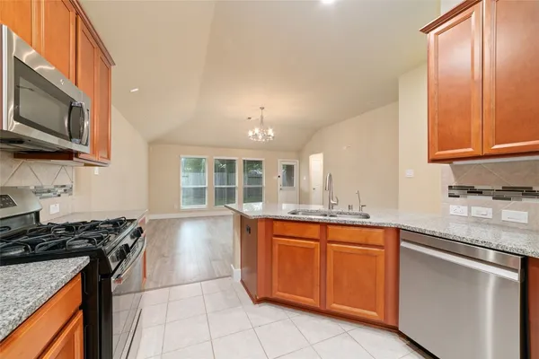 a kitchen with stainless steel appliances granite countertop a sink stove and microwave