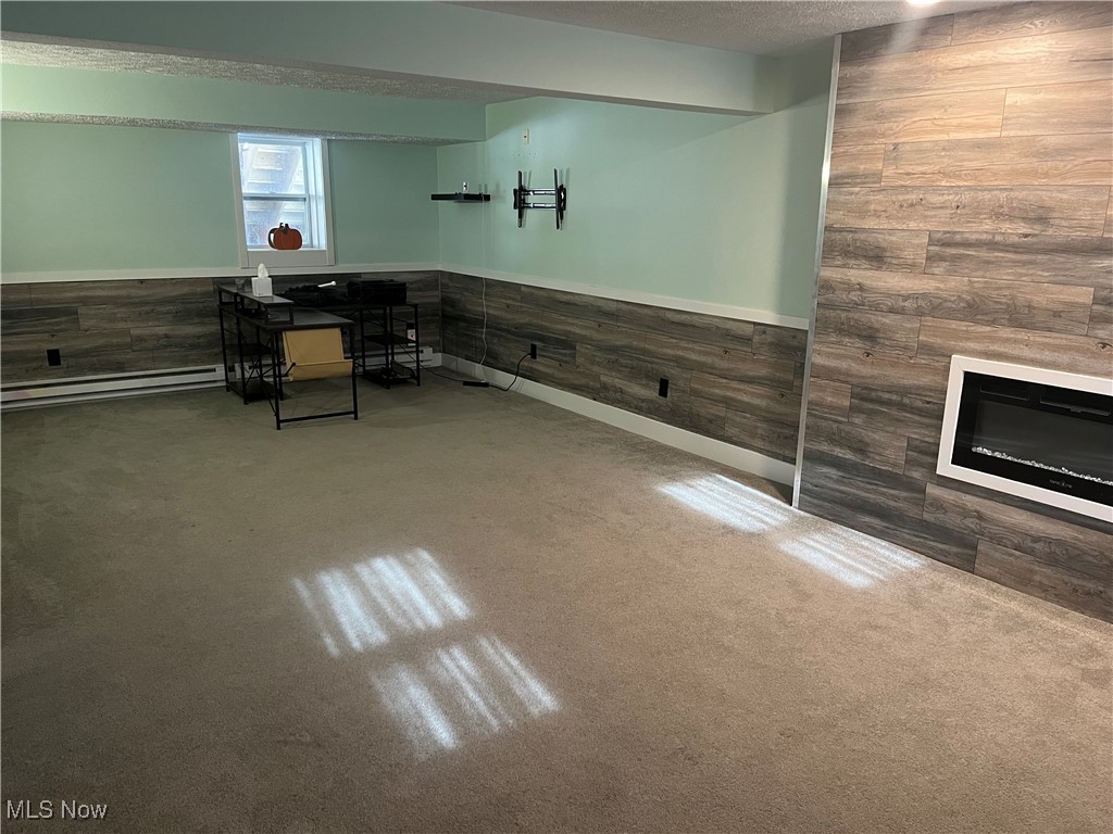 2583 Ridgewood Road Akron, OH 44313 - Photo 20 of 29 Basement with carpet flooring, a textured ceiling, a baseboard radiator, and wood walls