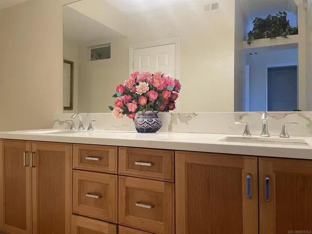a bathroom with a granite countertop sink mirror and cabinets