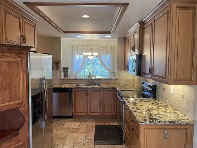 a kitchen with stainless steel appliances granite countertop a sink stove and refrigerator