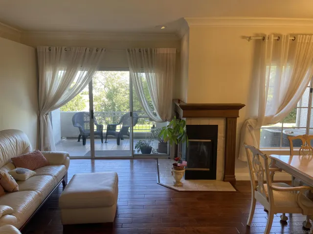 a living room with furniture a fireplace and a large window