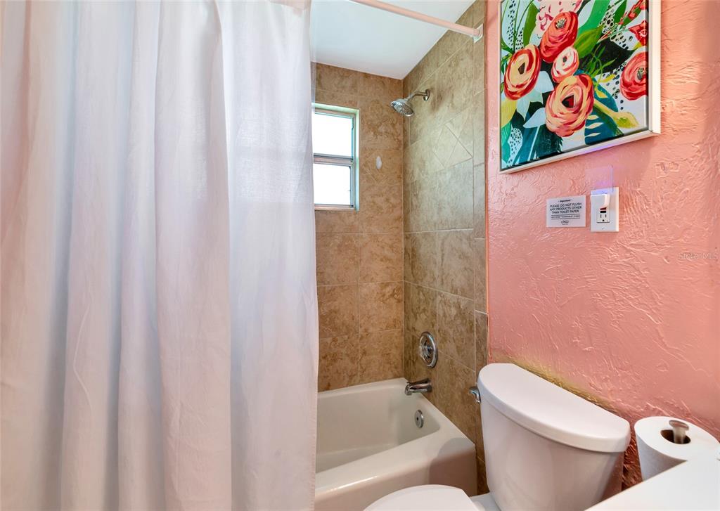 5948 Mirror Lake Road Sarasota, FL 34233 - Photo 12 of 50 a white toilet sitting next to a bath tub