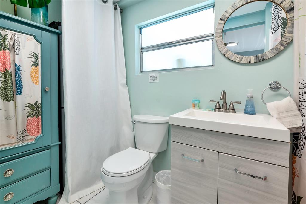 5948 Mirror Lake Road Sarasota, FL 34233 - Photo 18 of 50 a bathroom with a sink a mirror a toilet and a window