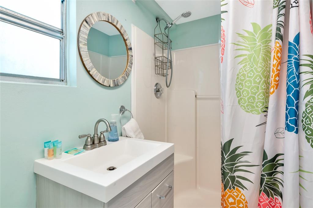 5948 Mirror Lake Road Sarasota, FL 34233 - Photo 19 of 50 a bathroom with a sink a mirror and a shower curtain