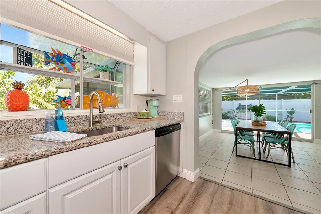 5948 Mirror Lake Road Sarasota, FL 34233 - Photo 27 of 50 a kitchen with stainless steel appliances granite countertop a sink and a wooden cabinets