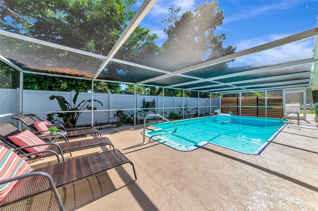 5948 Mirror Lake Road Sarasota, FL 34233 - Photo 33 of 50 a view of a backyard with table and chairs under an umbrella