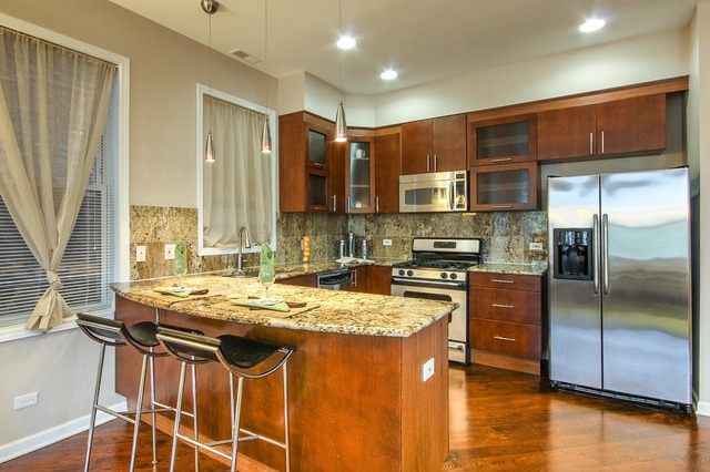 4115 South Drexel Boulevard, Unit 2F Chicago, IL 60653 - Photo 7 of 17 a kitchen with stainless steel appliances granite countertop a stove a sink and a refrigerator