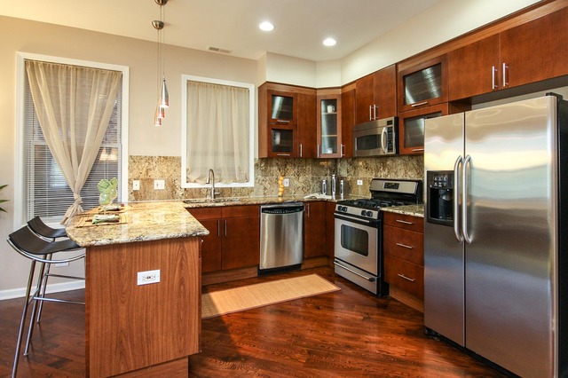 4115 South Drexel Boulevard, Unit 2F Chicago, IL 60653 - Photo 8 of 17 a kitchen with stainless steel appliances granite countertop a stove a sink and a refrigerator