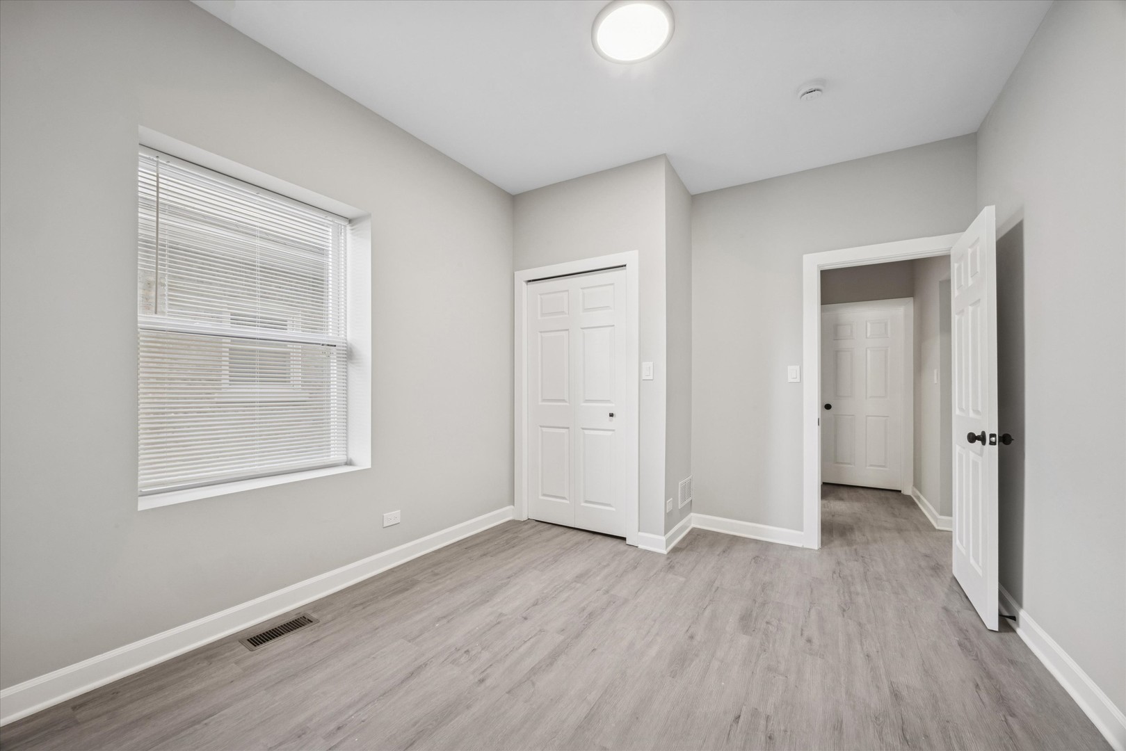 8018 South Harvard Avenue, Unit 2 Chicago, IL 60620 - Photo 12 of 14 a view of an empty room with wooden floor and a window