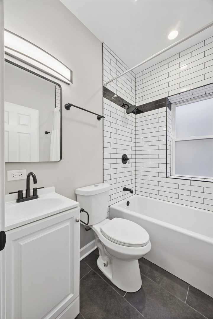8018 South Harvard Avenue, Unit 2 Chicago, IL 60620 - Photo 13 of 14 a bathroom with a toilet sink vanity and bathtub