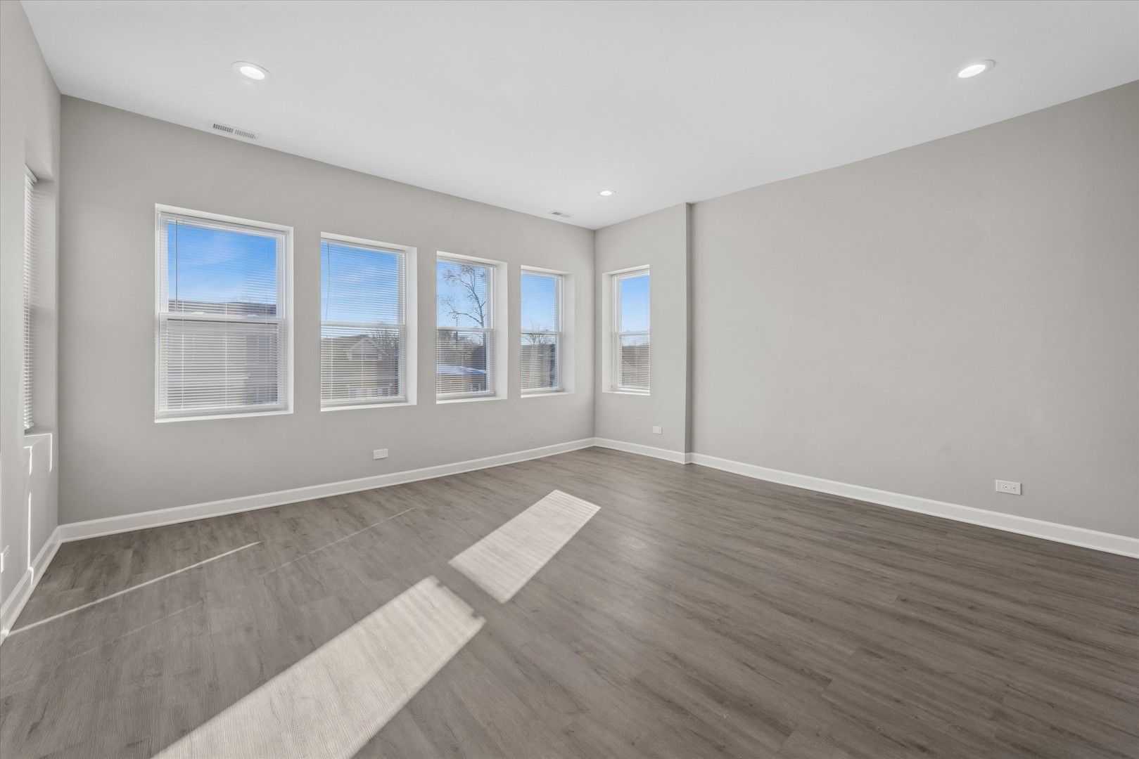 8018 South Harvard Avenue, Unit 2 Chicago, IL 60620 - Photo 5 of 14 a view of an empty room with wooden floor and windows