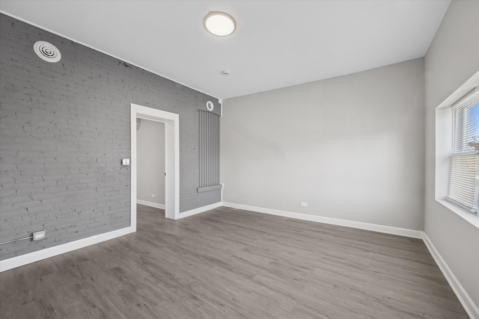 8018 South Harvard Avenue, Unit 2 Chicago, IL 60620 - Photo 7 of 14 an empty room with wooden floor and windows