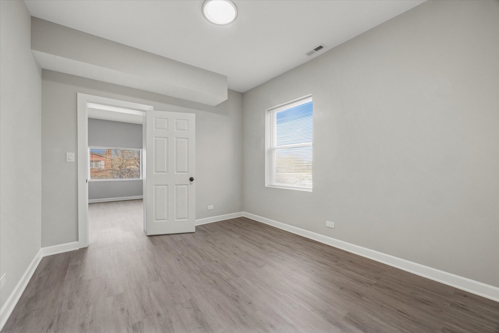 8018 South Harvard Avenue, Unit 2 Chicago, IL 60620 - Photo 8 of 14 an empty room with wooden floor and windows