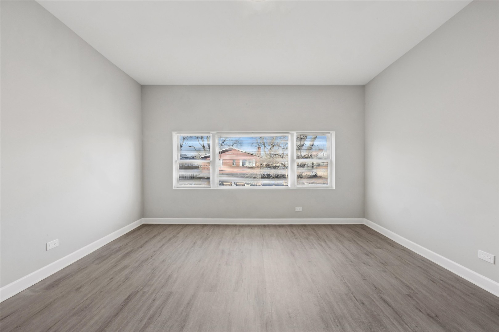 8018 South Harvard Avenue, Unit 2 Chicago, IL 60620 - Photo 9 of 14 a view of an empty room with wooden floor and a window