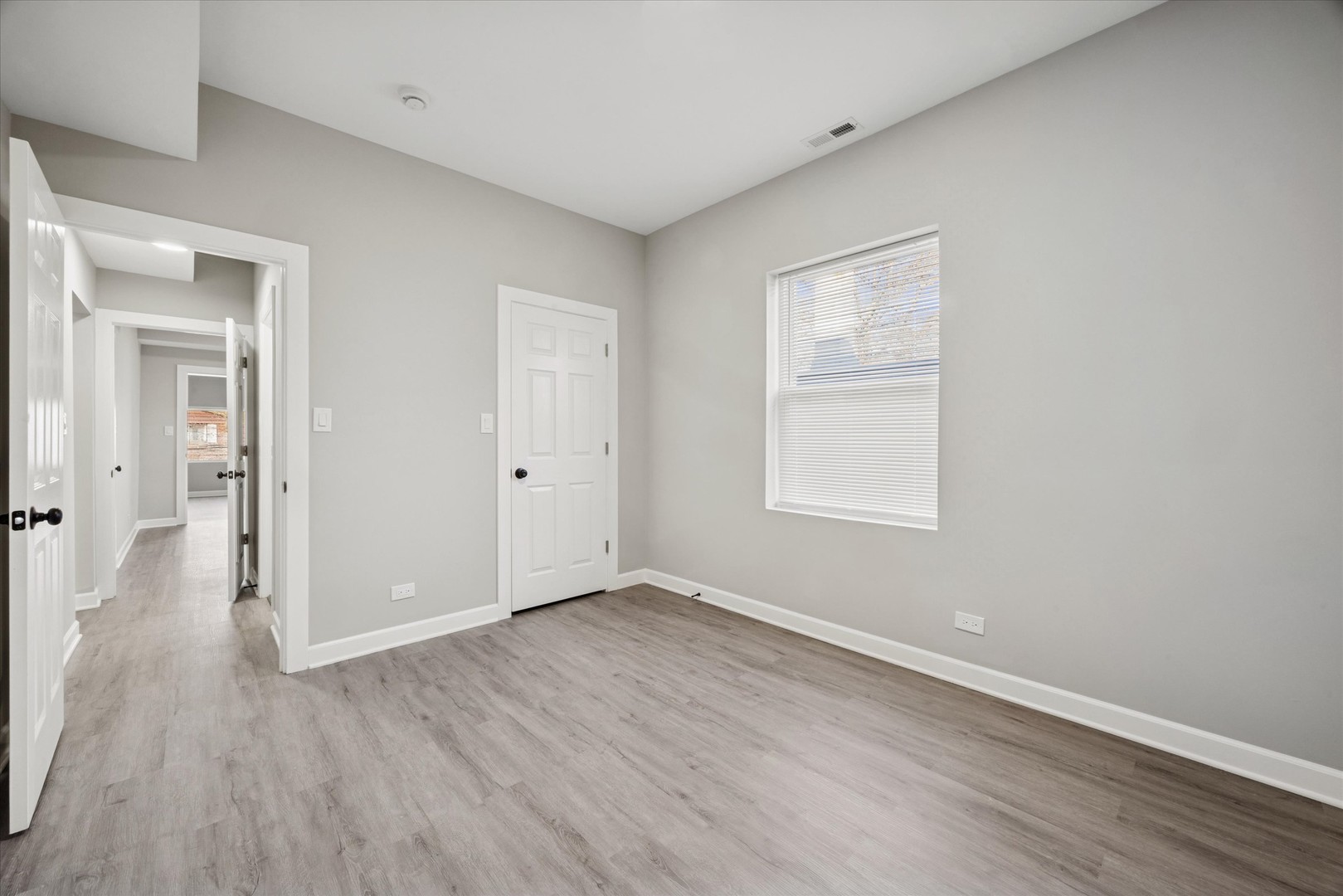 8018 South Harvard Avenue, Unit 2 Chicago, IL 60620 - Photo 10 of 14 a view of an empty room with wooden floor and a window