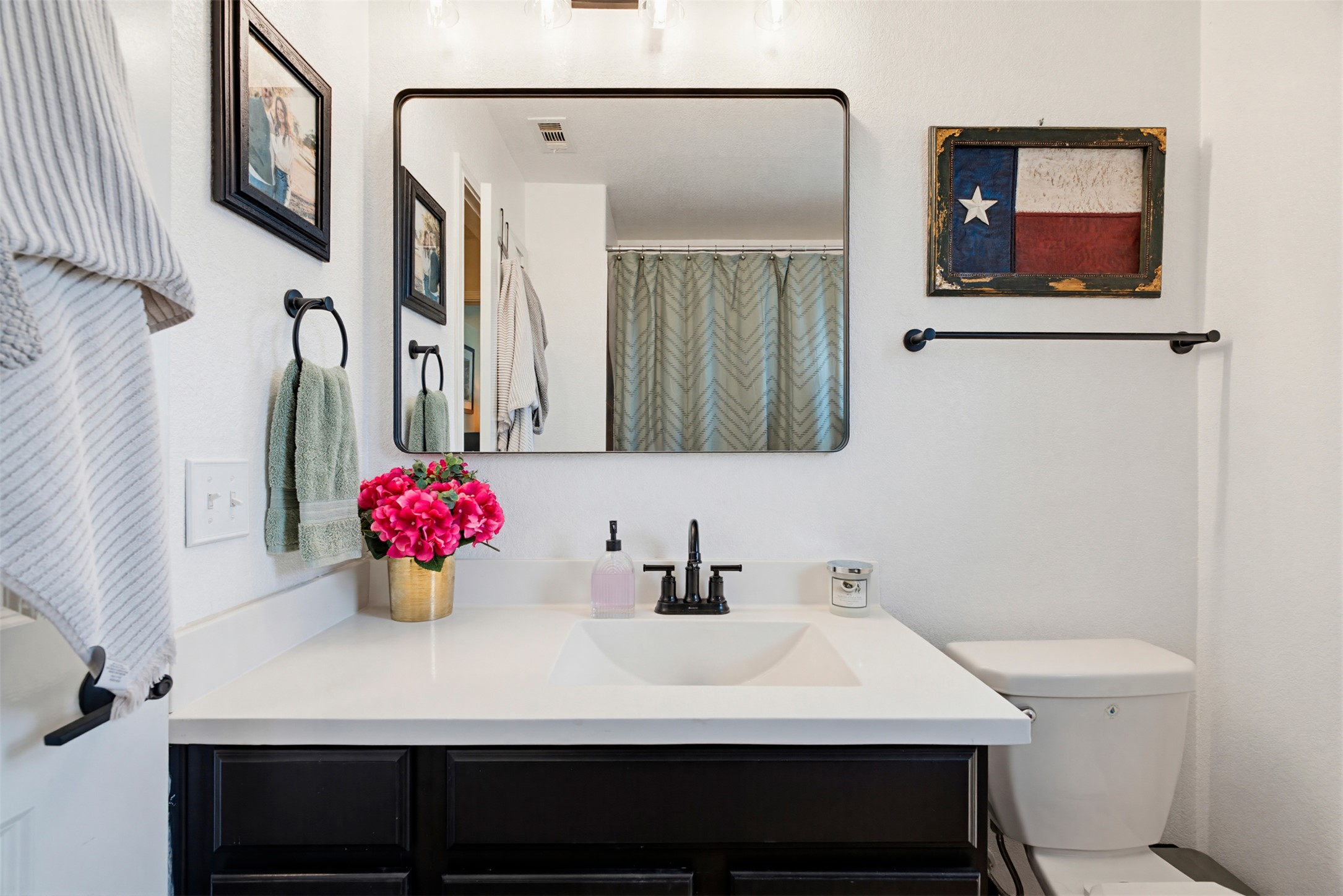 5705 Southerner Way Austin, TX 78747 - Photo 14 of 22 A well-appointed bathroom features a single vanity with a sleek countertop and a modern mirror.