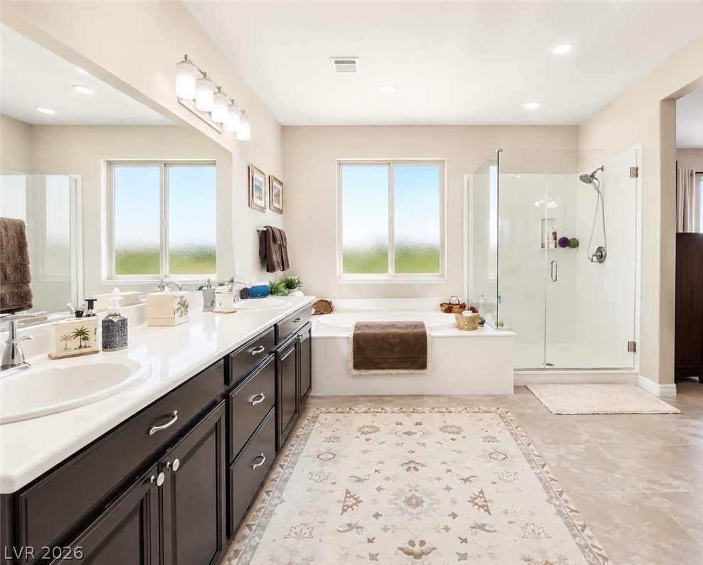 9724 University Ridge Avenue Las Vegas, NV 89149 - Photo 48 of 61 Indulge in a tranquil retreat featuring dual vanities, a deep soaking tub, and a separate glass-enclosed shower.