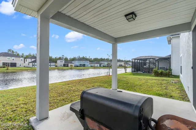 a view of a patio with lawn chairs floor to ceiling window and yard
