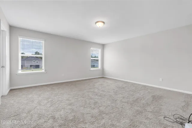 an empty room with windows and closet