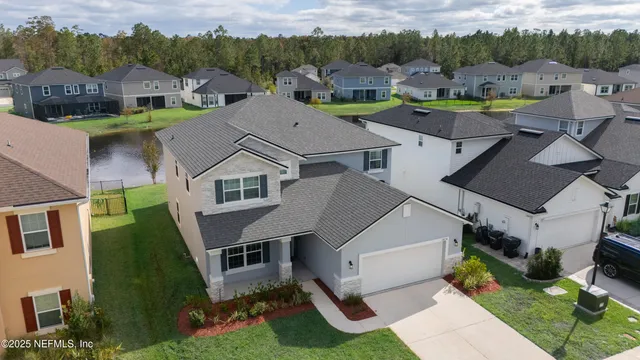 an aerial view of a house with swimming pool and a yard