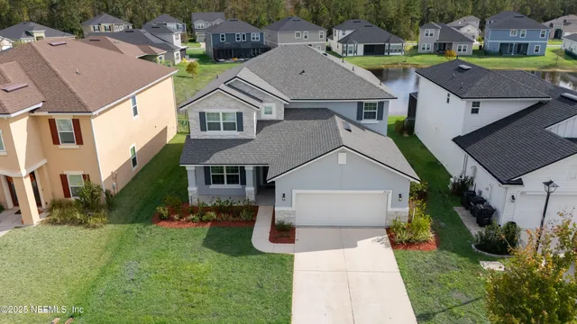 a aerial view of a house with a yard and potted plants
