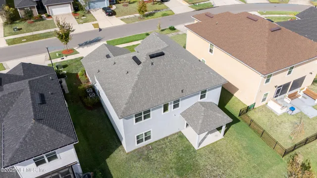 an aerial view of a house with a yard and a swimming pool