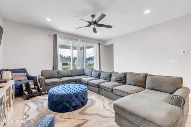 a living room with furniture a ceiling fan and a window