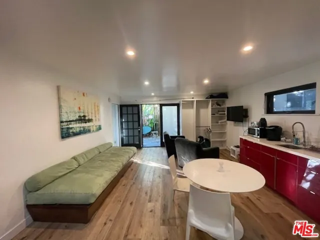 a living room with furniture kitchen view and a large window