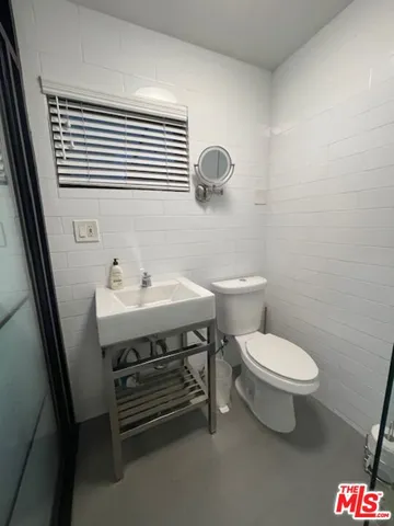 a bathroom with a sink a toilet and mirror