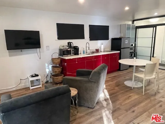 a living room with furniture a flat screen tv and kitchen view