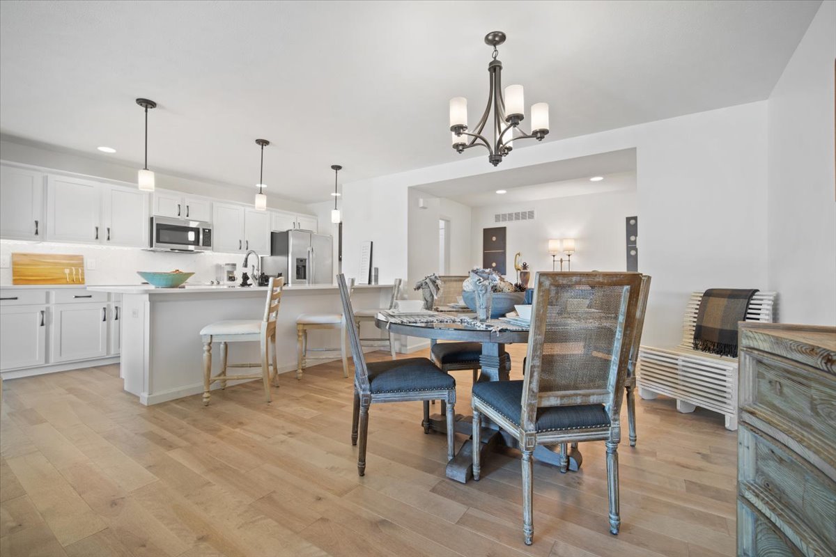 1423 Pine Forest Drive Normal, IL 61761 - Photo 11 of 23 a view of a dining room and livingroom with furniture wooden floor a rug a painting and a chandelier