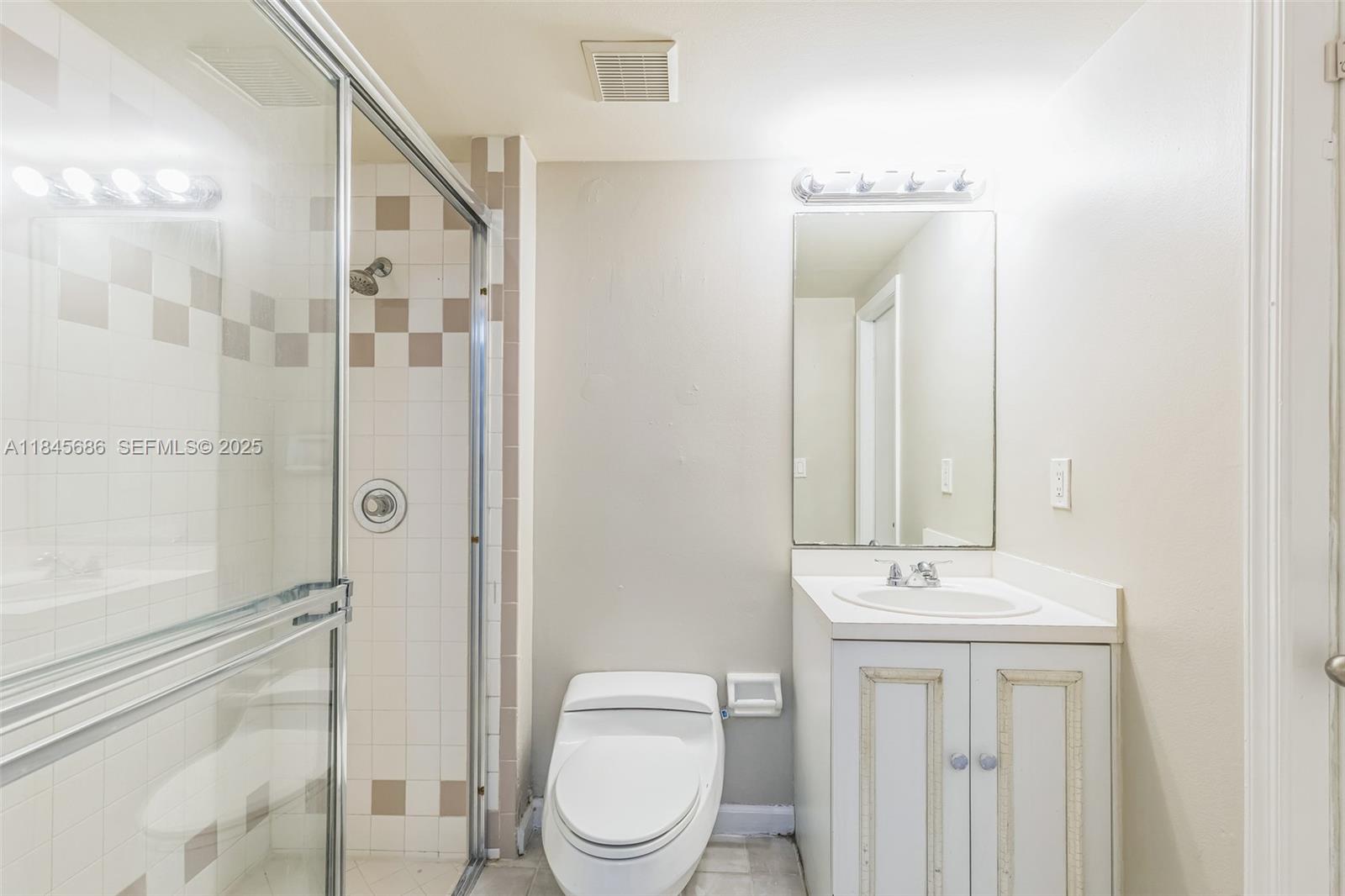 18091 Southwest 22nd Street Miramar, FL 33029 - Photo 15 of 41 a bathroom with a toilet a sink and mirror