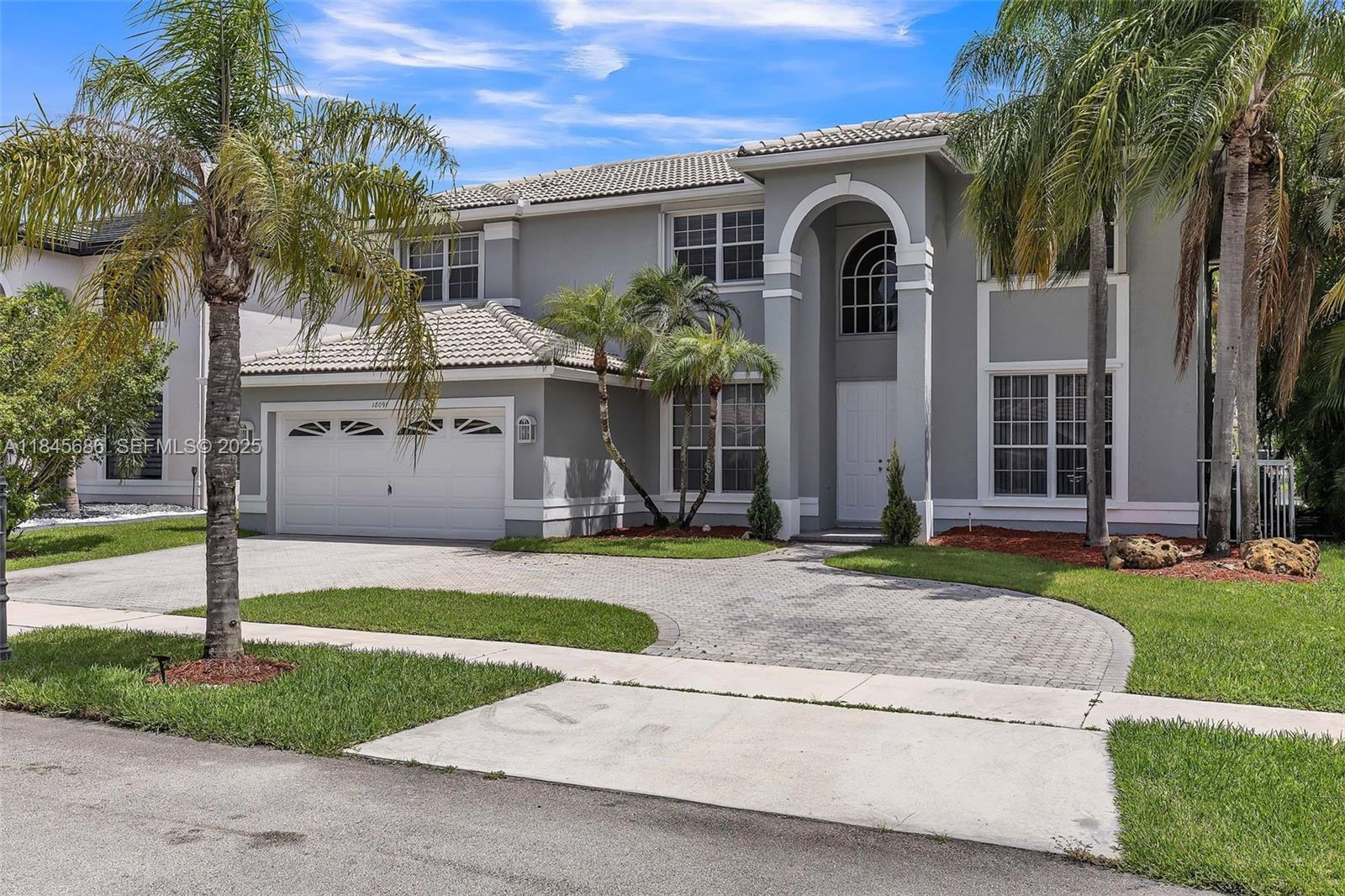 18091 Southwest 22nd Street Miramar, FL 33029 - Photo 2 of 41 a front view of a house with a yard and garage