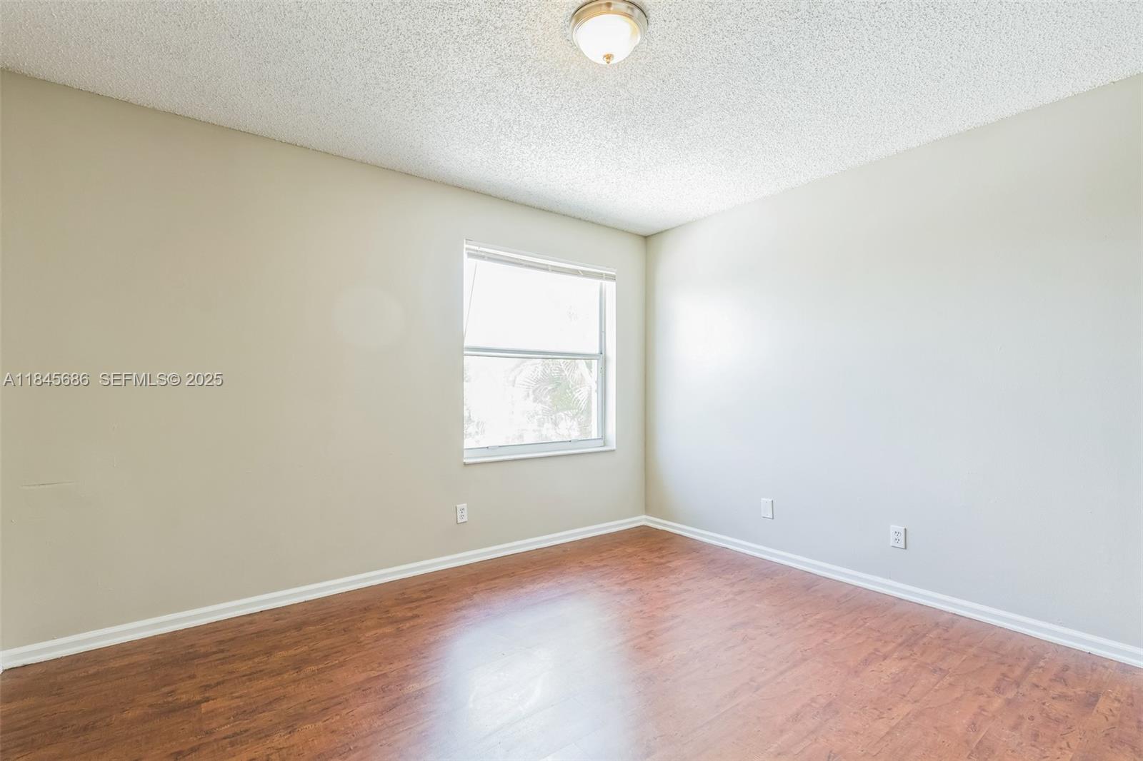 18091 Southwest 22nd Street Miramar, FL 33029 - Photo 29 of 41 an empty room with wooden floor and windows