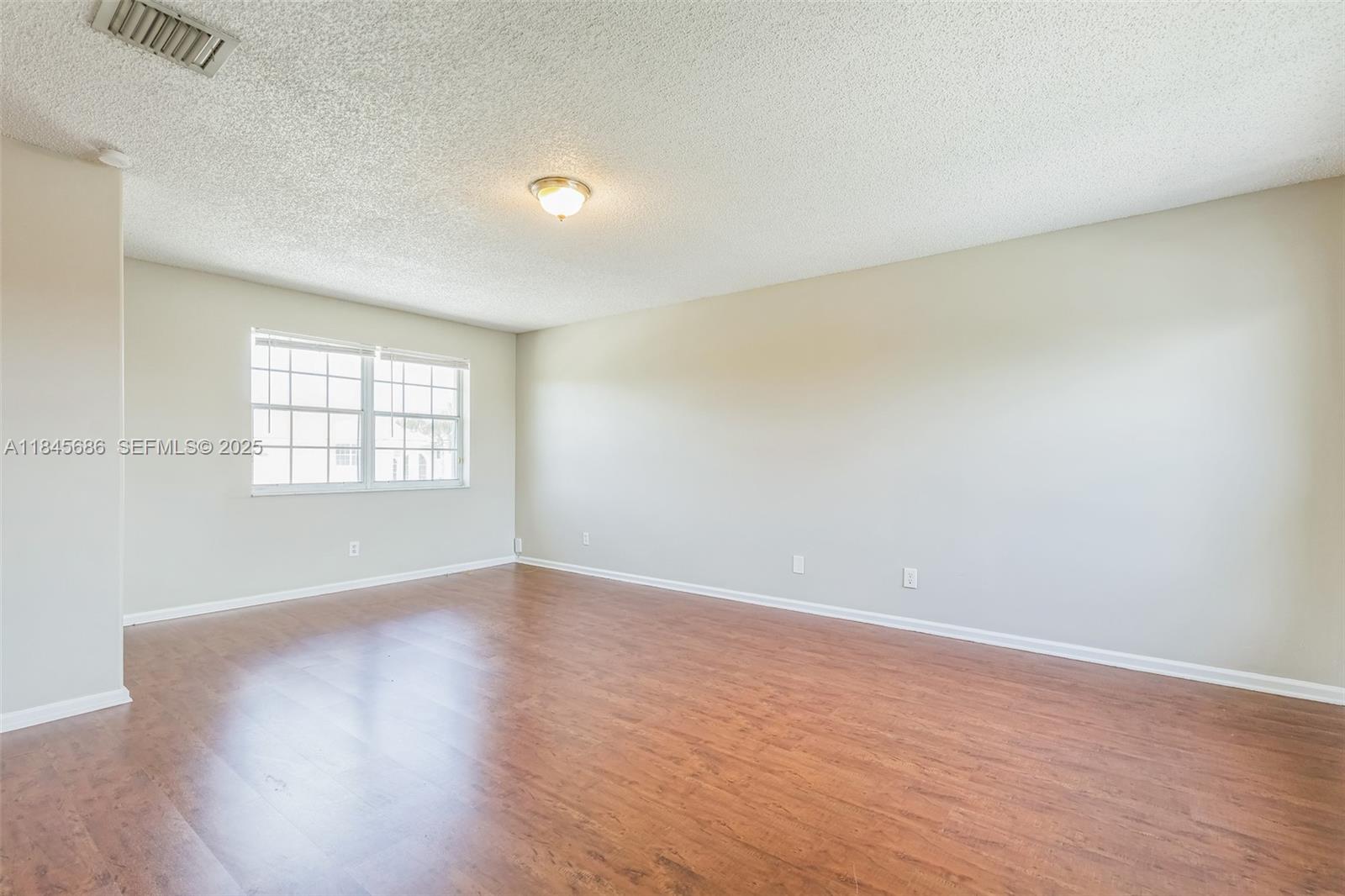 18091 Southwest 22nd Street Miramar, FL 33029 - Photo 31 of 41 an empty room with wooden floor and windows