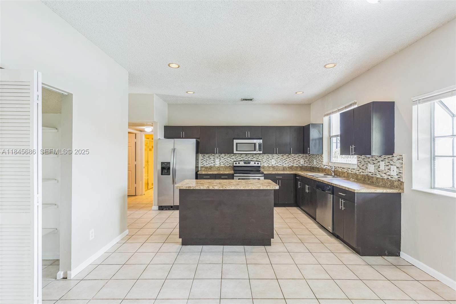 18091 Southwest 22nd Street Miramar, FL 33029 - Photo 7 of 41 a kitchen with stainless steel appliances granite countertop a refrigerator and a stove