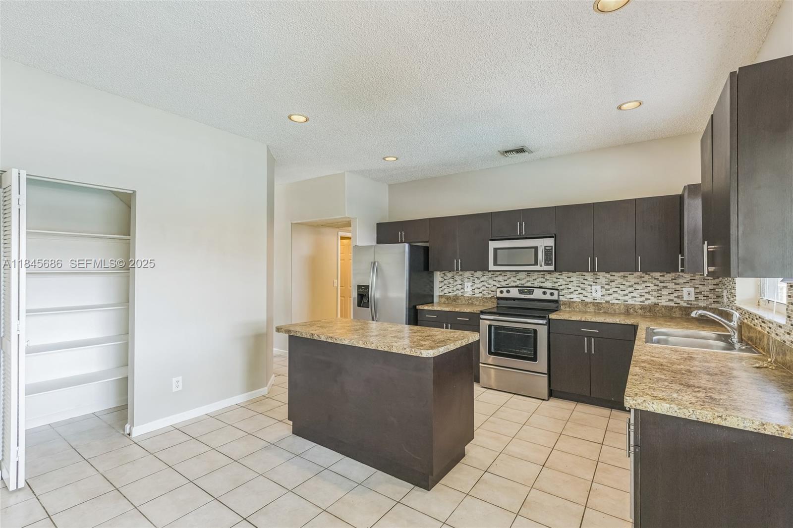 18091 Southwest 22nd Street Miramar, FL 33029 - Photo 9 of 41 a large kitchen with cabinets