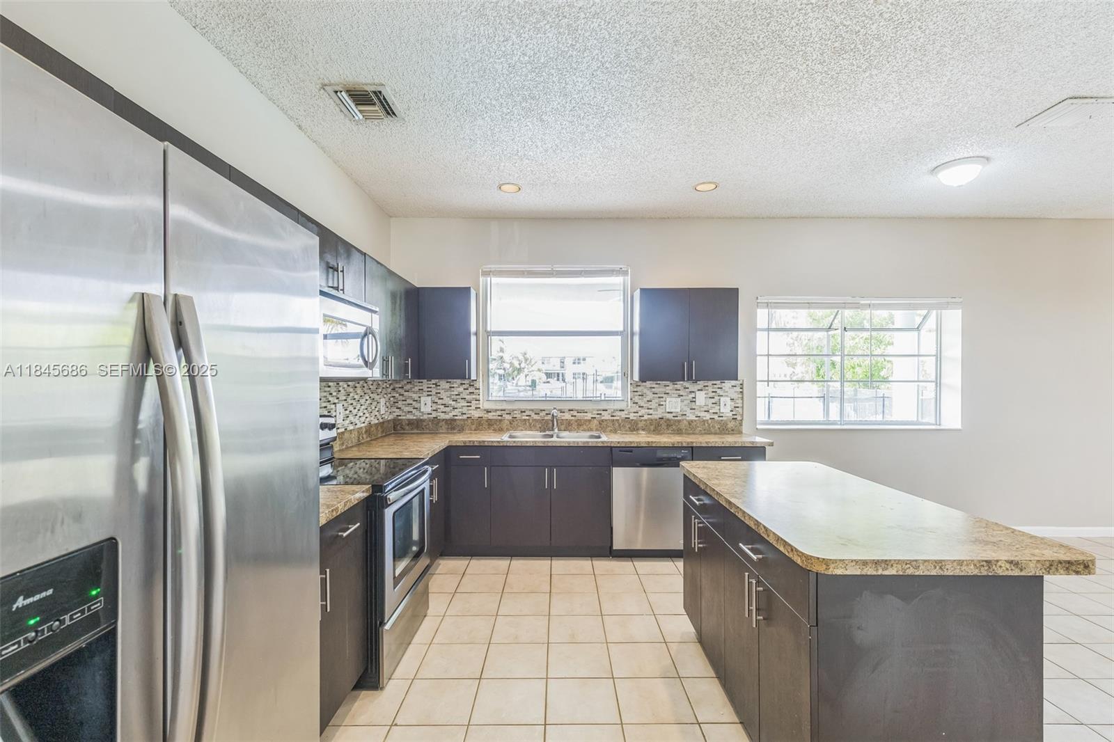 18091 Southwest 22nd Street Miramar, FL 33029 - Photo 10 of 41 a kitchen with stainless steel appliances granite countertop a sink stove and refrigerator