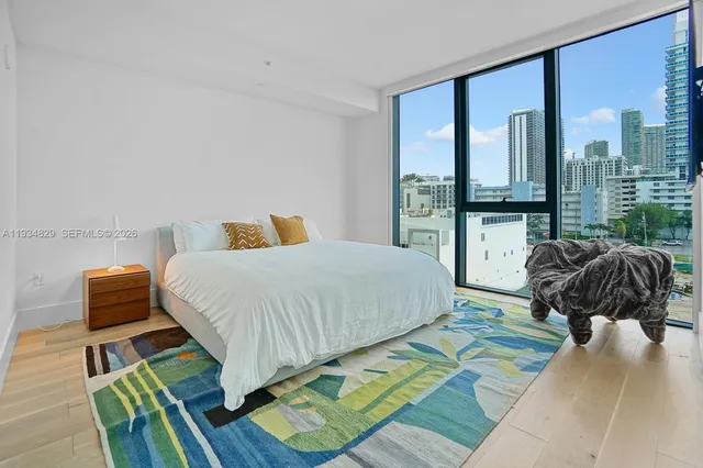 a bedroom with a bed and a large window