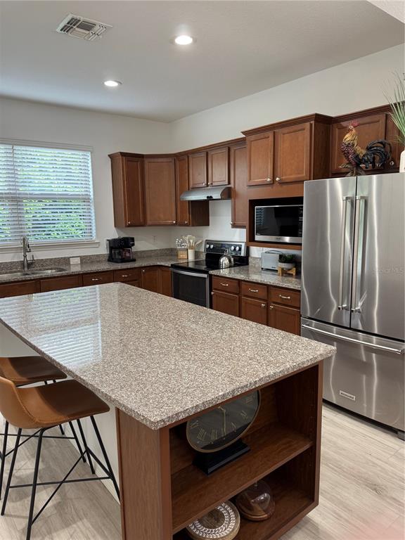 9122 Southwest 70th Loop Ocala, FL 34481 - Photo 31 of 31 a kitchen with kitchen island a sink table and chairs