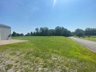 a view of a green field with wooden fence