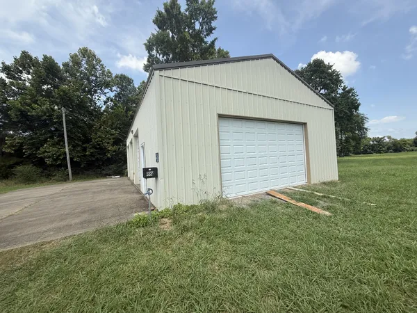 a view of backyard of house and garage