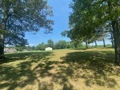 a view of outdoor space with green field and trees all around