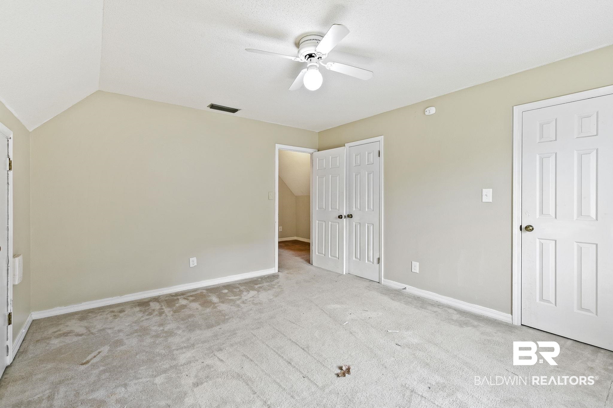 474 Ridgewood Drive Daphne, AL 36526 - Photo 37 of 57 Unfurnished bedroom with lofted ceiling, light carpet, and ceiling fan