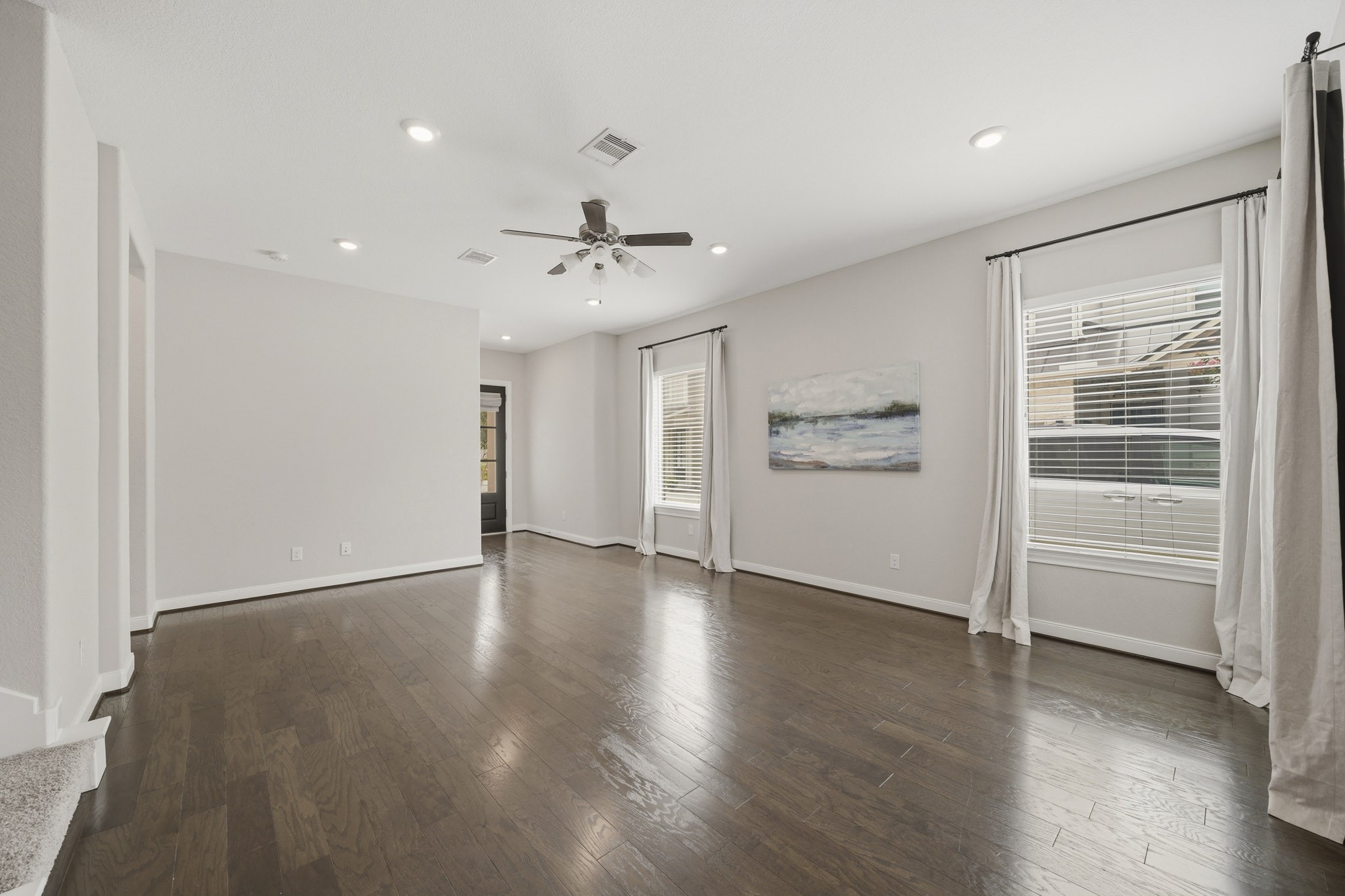 4103 Tranquil Square Road Houston, TX 77043 - Photo 7 of 39 A generously sized window framed with blinds and drapes brightens the space, complemented by a ceiling fan with integrated light for everyday comfort.