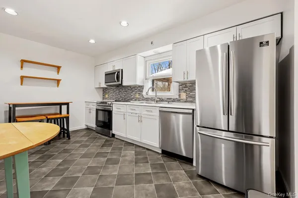 a kitchen with stainless steel appliances granite countertop a refrigerator sink and stove