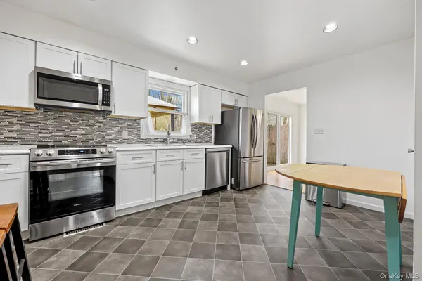 a kitchen with stainless steel appliances a stove a sink cabinets and a refrigerator