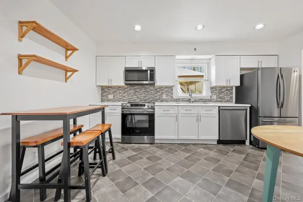 a kitchen with stainless steel appliances a stove a sink island and a refrigerator