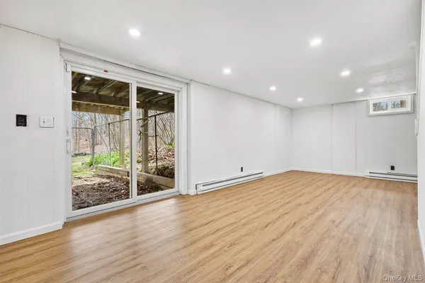 an empty room with wooden floor and sliding door