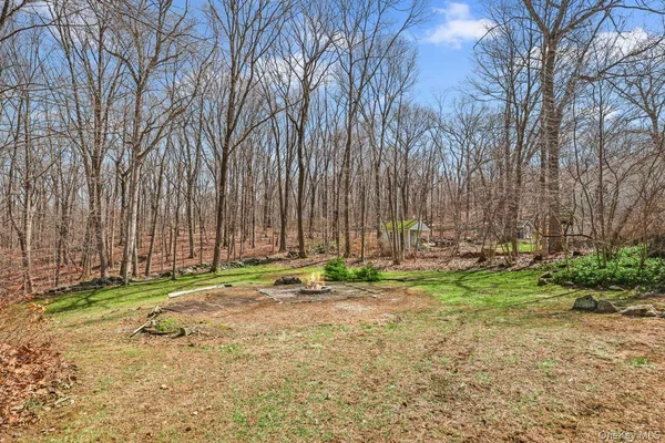 a backyard of a house with a yard and large trees